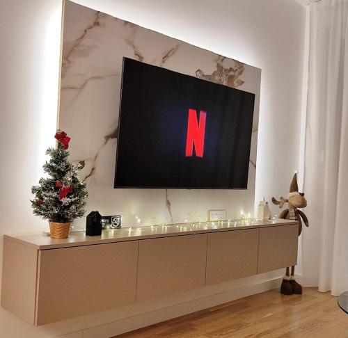 a television with the letter n on a wall at Apartment Feel Banja Luka in Banja Luka