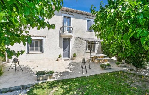une maison avec une terrasse, une table et un banc dans l'établissement 3 Bedroom Gorgeous Home In Vallabrègues, à Vallabrègues