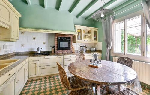 une cuisine avec une table et des chaises dans une cuisine dans l'établissement 3 Bedroom Gorgeous Home In Vallabrègues, à Vallabrègues