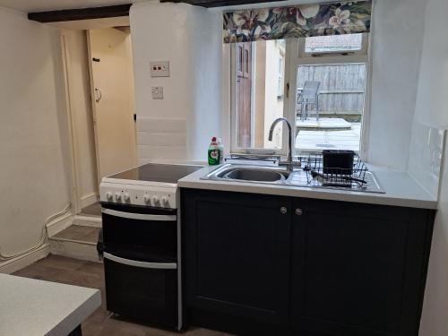a kitchen with a sink and a stove at Cottage in Wells in Wells