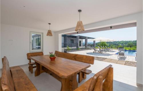 a dining room with a wooden table and benches at Gorgeous Home In Grubine in Grubine