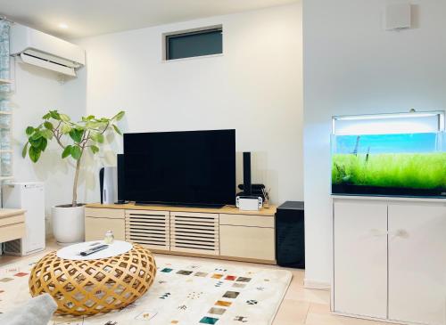 a living room with a flat screen tv and a ottoman at Alo BnB 7 - Near IKEBUKURO, SHINJUKU, UENO - Self Check in - OYAMA Sta 3min in Tokyo