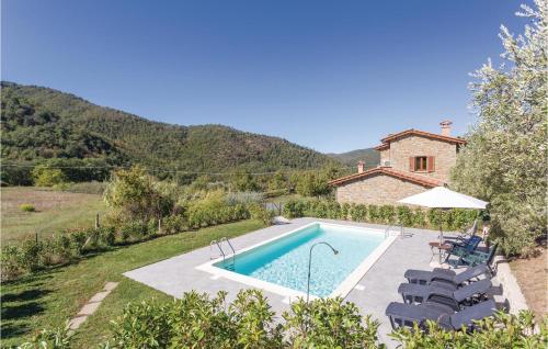 una piscina en un jardín con sillas y una casa en Le Libellule, en Piegaio