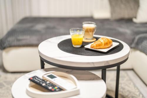 a table with two glasses of orange juice and a plate of food at Apartman Nika in Vukovar