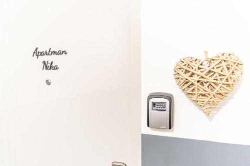 a heart hanging on a wall next to a meter at Apartman Nika in Vukovar