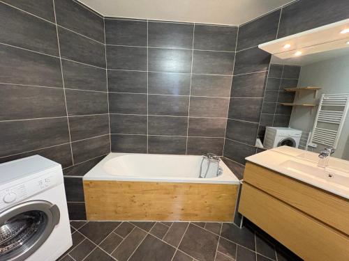La salle de bains est pourvue d'une baignoire, d'un lavabo et d'un lave-linge. dans l'établissement Charmant duplex pour 6 personnes avec cheminée et balcon exposé sud à Avoriaz - FR-1-314-199, à Morzine