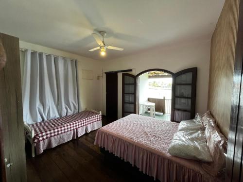 Ένα ή περισσότερα κρεβάτια σε δωμάτιο στο Casa pé na areia com vista deslumbrante