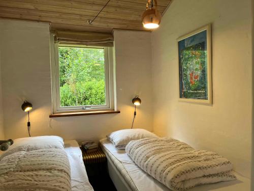 a bedroom with two beds and a window at Cosy Summer Cottage Glose To Sandy Beach! in Knebel