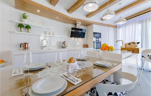 a white kitchen with a dining table and chairs at Beautiful Home In Sutivan With Wifi in Sutivan
