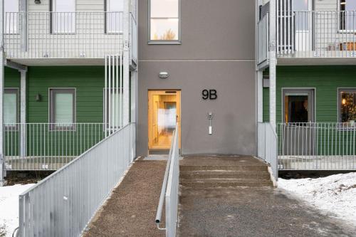 a walkway leading to a building with a yellow door at Guestly Homes - 1BR Scandinavian Charm in Piteå