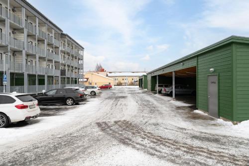 a snow covered street in a parking lot at Guestly Homes - 1BR Scandinavian Charm in Piteå