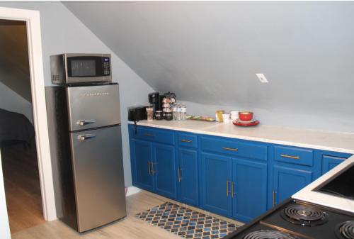 a kitchen with blue cabinets and a stainless steel refrigerator at Keri APRN LLC in Ansonia