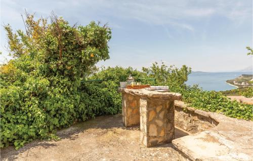 a stone wall with an orange tree and the ocean at Two-Bedroom Holiday Home In Tucepi in Tučepi