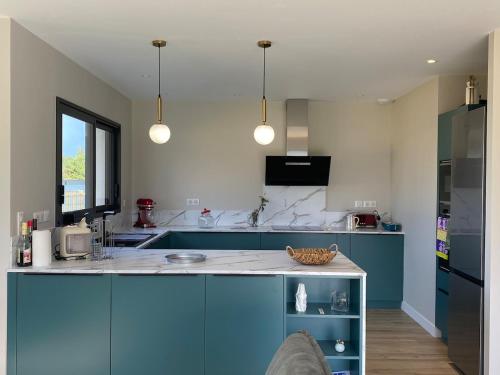 une cuisine avec des armoires bleues et un comptoir dans l'établissement Amzer Zo Loctudy, à Loctudy
