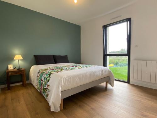 une chambre avec un grand lit et une fenêtre dans l'établissement Amzer Zo Loctudy, à Loctudy