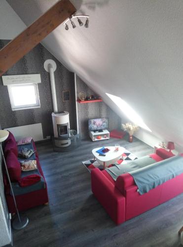 a living room with a red couch and a table at Vielle-aure le 2bers 90 M2 avec linge in Vielle-Aure