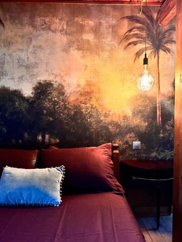 - une chambre avec un mur orné d'une fresque murale de palmiers dans l'établissement La Grande Ourse, à Saint-Pierre-de-Varennes