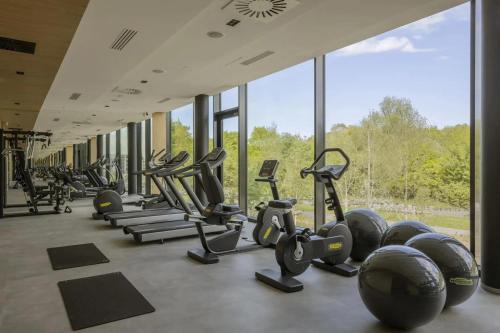 a row of exercise machines in a gym with windows at Apartament WHITE GLOVE Prestige Tarasy Bałtyku PLAŻA in Gdańsk