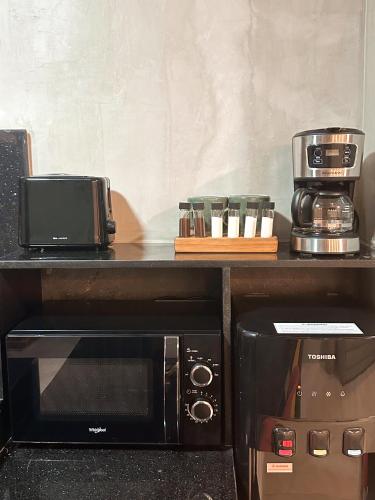 a microwave sitting on a counter next to a coffee maker at Blue Tulip - Rooms with Jacuzzi in Lapu Lapu City