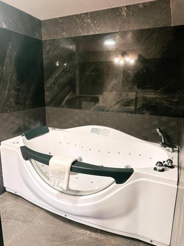 a bath tub with a towel on the side of it at Blue Tulip - Rooms with Jacuzzi in Lapu Lapu City