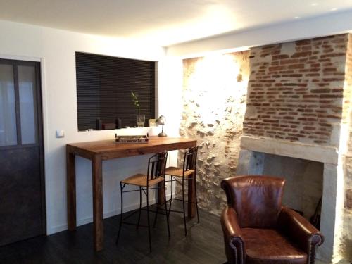 a room with a table and chairs and a fireplace at Charme Atypique in La Rochelle