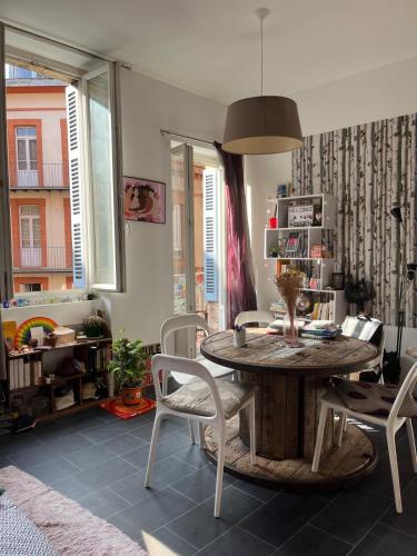 une salle à manger avec une table et des chaises en bois dans l'établissement studio balcon toulouse gare, à Toulouse