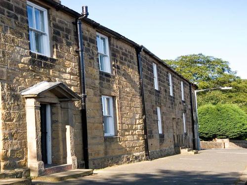 a brick building with windows on the side of it at Alnwick Holiday House - Charming, Historic, Central Alnwick with Courtyard in Alnwick