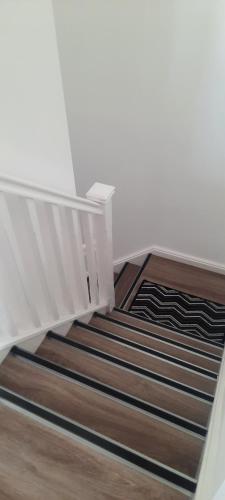 a stairway with a white railing and wooden stairs at Lanarkshire Apartment- Views- Sleeps 4- Balcony in Larkhall