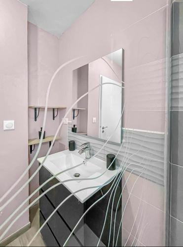 une salle de bain avec un lavabo et un miroir dans l'établissement Maison de charme 5 min de la plage, à Saint-Hilaire-de-Riez