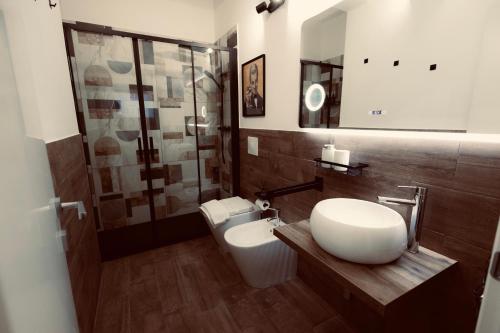a bathroom with a toilet and a sink and a shower at Elene Suites Soggiorno Mediterraneo in Palermo