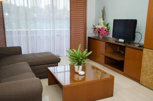 a living room with a couch and a tv at The Maple Suite in Kuala Lumpur