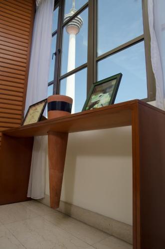 a wooden desk with two pictures on it in front of a window at The Maple Suite in Kuala Lumpur