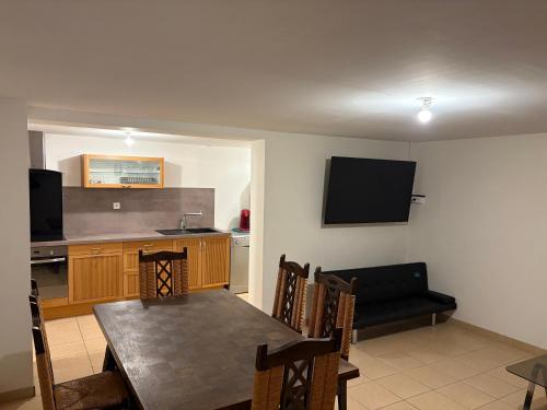 une cuisine et une salle à manger avec une table et une télévision dans l'établissement T2 pour 5 personnes 1 chambre, à Satolas-et-Bonce