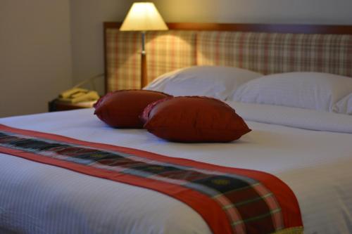 a bed with two red pillows on top of it at The Maple Suite in Kuala Lumpur