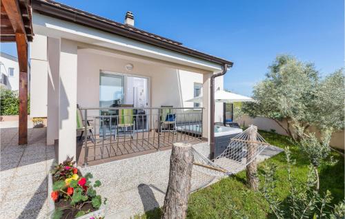 a house with a porch with a swing at Nice Home In Valbandon With Jacuzzi in Valbandon
