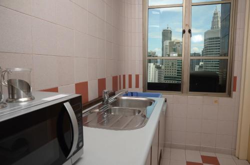 a bathroom with a sink and a window at The Maple Suite in Kuala Lumpur