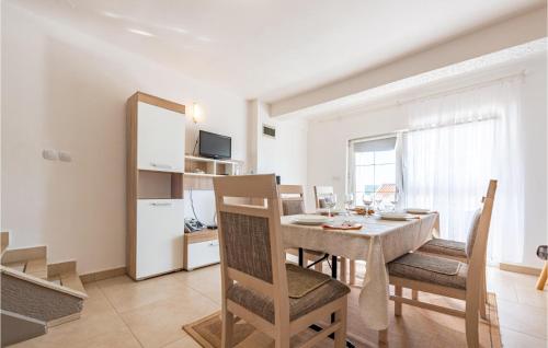 een keuken en eetkamer met een tafel en stoelen bij Amazing Apartment In Stara Novalja in Stara Novalja