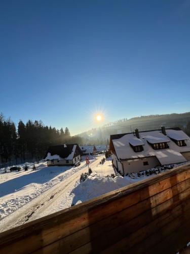 a winter scene with snow on the roofs of houses at Slunečný apartmán in Cerny Dul