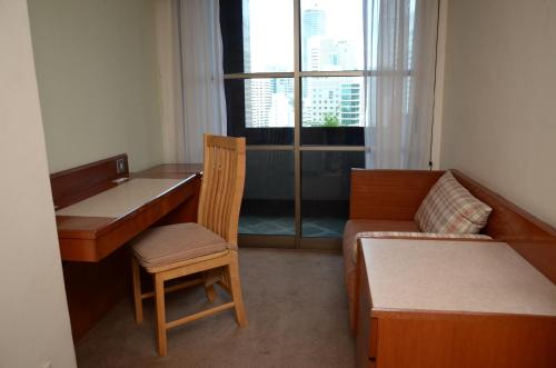 a room with a desk and a bed and a desk and a chair at The Maple Suite in Kuala Lumpur