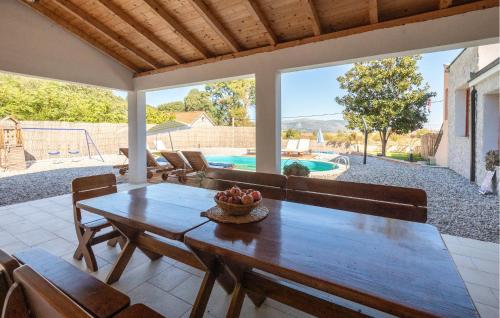 a dining room with a table and chairs and a pool at Amazing Home In Kula Norinska With Wifi in Kula Norinska