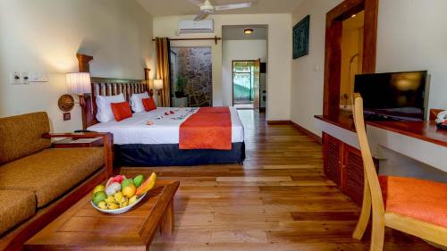 a hotel room with a bed and a bowl of fruit on a table at Siddhalepa Ayurveda Resort - All Meals, Ayurveda Treatment and Yoga in Wadduwa