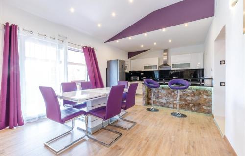 a dining room with a table and purple chairs at Beautiful Home In Hrvace With Wifi in Hrvace