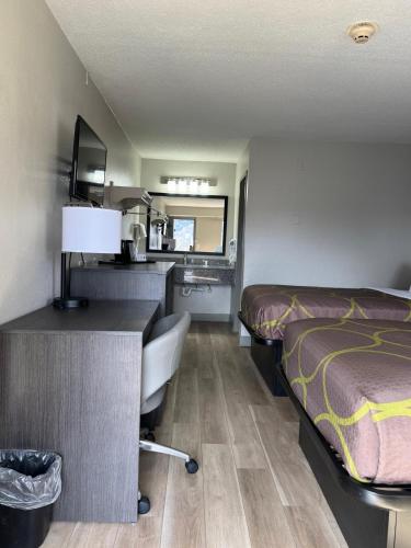 a hotel room with a bed and a desk at Super 8 by Wyndham Charleston WV in Charleston