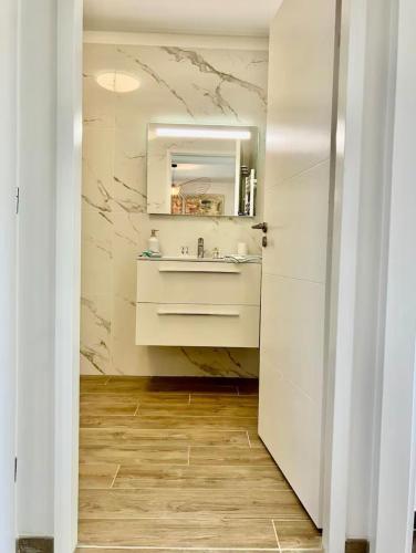 une salle de bain avec un lavabo et un miroir dans l'établissement La Casa de Betty, 4 personnes, Bord de Mer a Saint Florent, à Saint-Florent