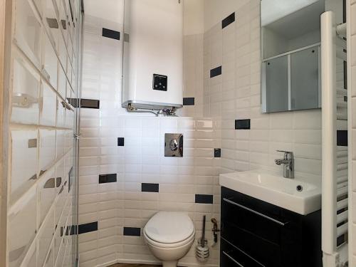 une salle de bain blanche avec des toilettes et un lavabo dans l'établissement Studio 150m Plage du Plat Gousset, à Granville