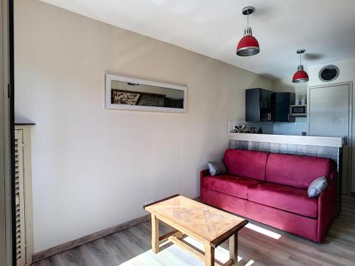 un salon avec un canapé rouge et une table dans l'établissement Studio 150m Plage du Plat Gousset, à Granville