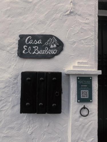 a sign on the side of a white building at Casa El Barbero 1810 in Benaocaz