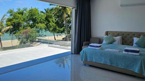 a bedroom with a bed and a view of the beach at So Good Poolvilla and Appartments Family Room in Prachuap Khiri Khan