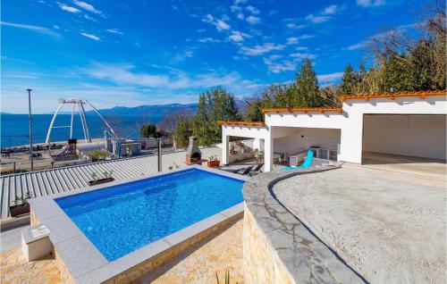 a swimming pool in front of a house at Lovely Home In Rijeka in Rijeka