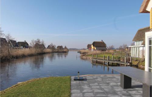 a view of a river with houses and a bench at Bodelaeke-Schiphuis Wellness 8 in Giethoorn